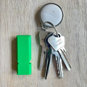 Whistle-Safe noodfluitje liggend naast sleutelbos – plat en licht ontwerp